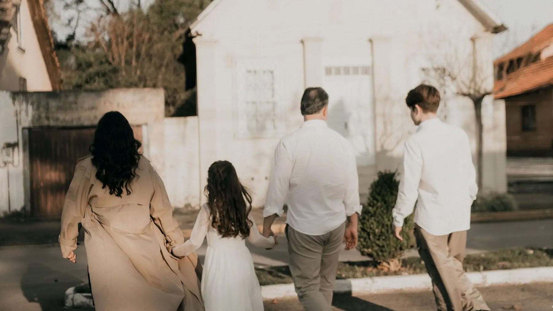 Familia caminando junta por la calle, vista de espaldas